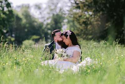 Les mariés assis dans le hautes herbes