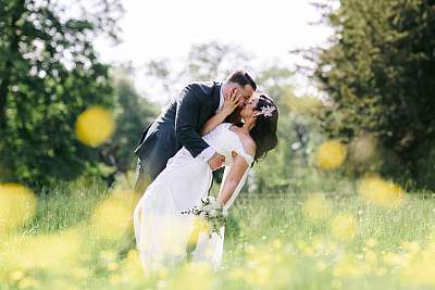 Pose classique des mariés au milieu des hautes herbes et des fleurs