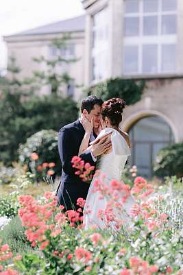 Les mariés lors de la séance photo de couple dans un jardin fleuri