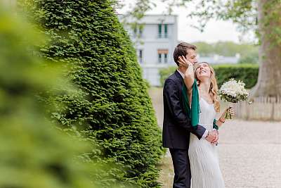 Les mariés enlacés dans le jardin de la mairie de Versailles