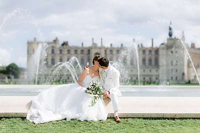 Les mariés s'embrassent tendrement devant le grand bassin royal de Saint-Germain-en-Laye