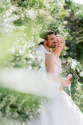 Les mariés assis au milieu d'un buisson de jasmin